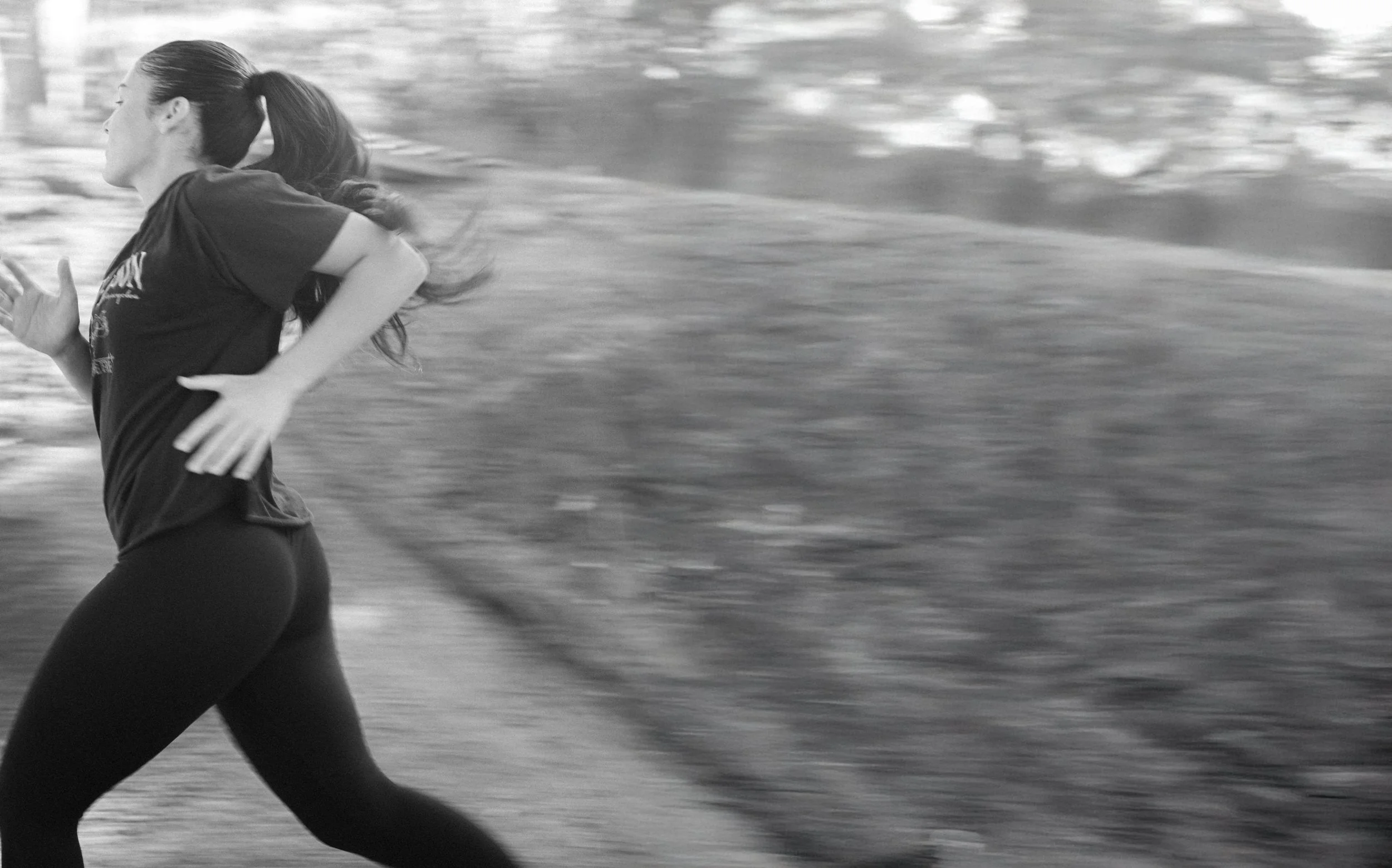 A black-and-white photograph of a runner mid-stride on a trail